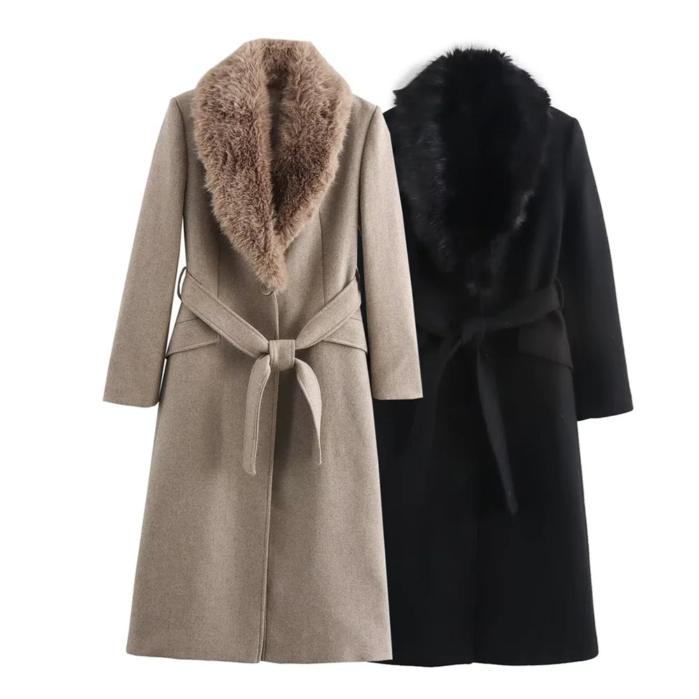 Two long belted coats with wide fur collars, shown side by side on a plain white background. The front coat is light taupe with a tan-brown fur collar, and the rear coat is black with a black fur collar.