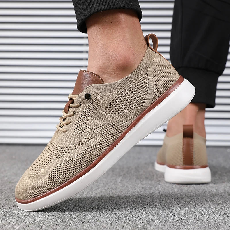 Beige casual shoes with brown accents worn by a person on a gray floor.