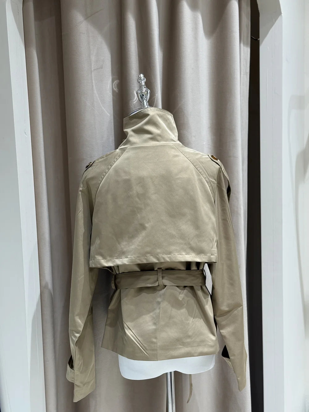 Beige jacket on a mannequin against a plain background