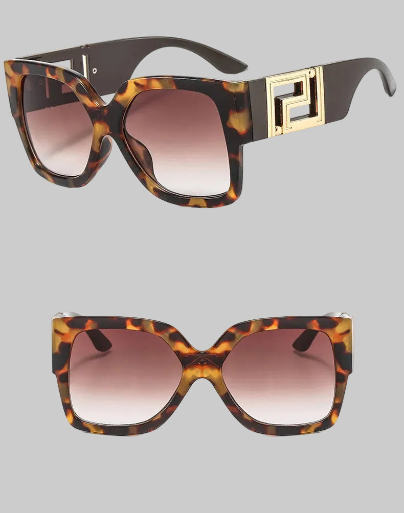 A pair of oversized square sunglasses with a brown and black tortoiseshell pattern, gradient brown lenses, and a prominent gold geometric frame detail on the temple. The image shows two views of the sunglasses against a white background with Chinese text and small descriptive text.