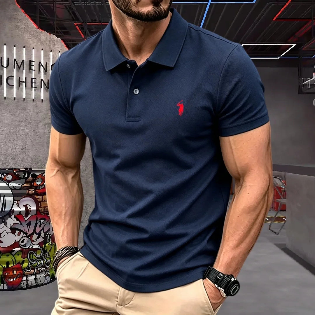 Man wearing a navy blue polo shirt with a red logo in an urban setting.