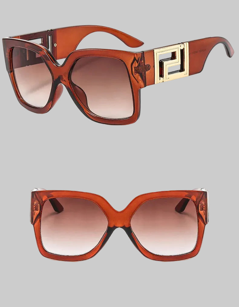 A pair of oversized square sunglasses with a translucent reddish-brown acetate frame, gradient brown lenses, and a prominent gold geometric metal accent on the temple. The image shows two views of the sunglasses against a white background with Chinese text and small descriptive text.